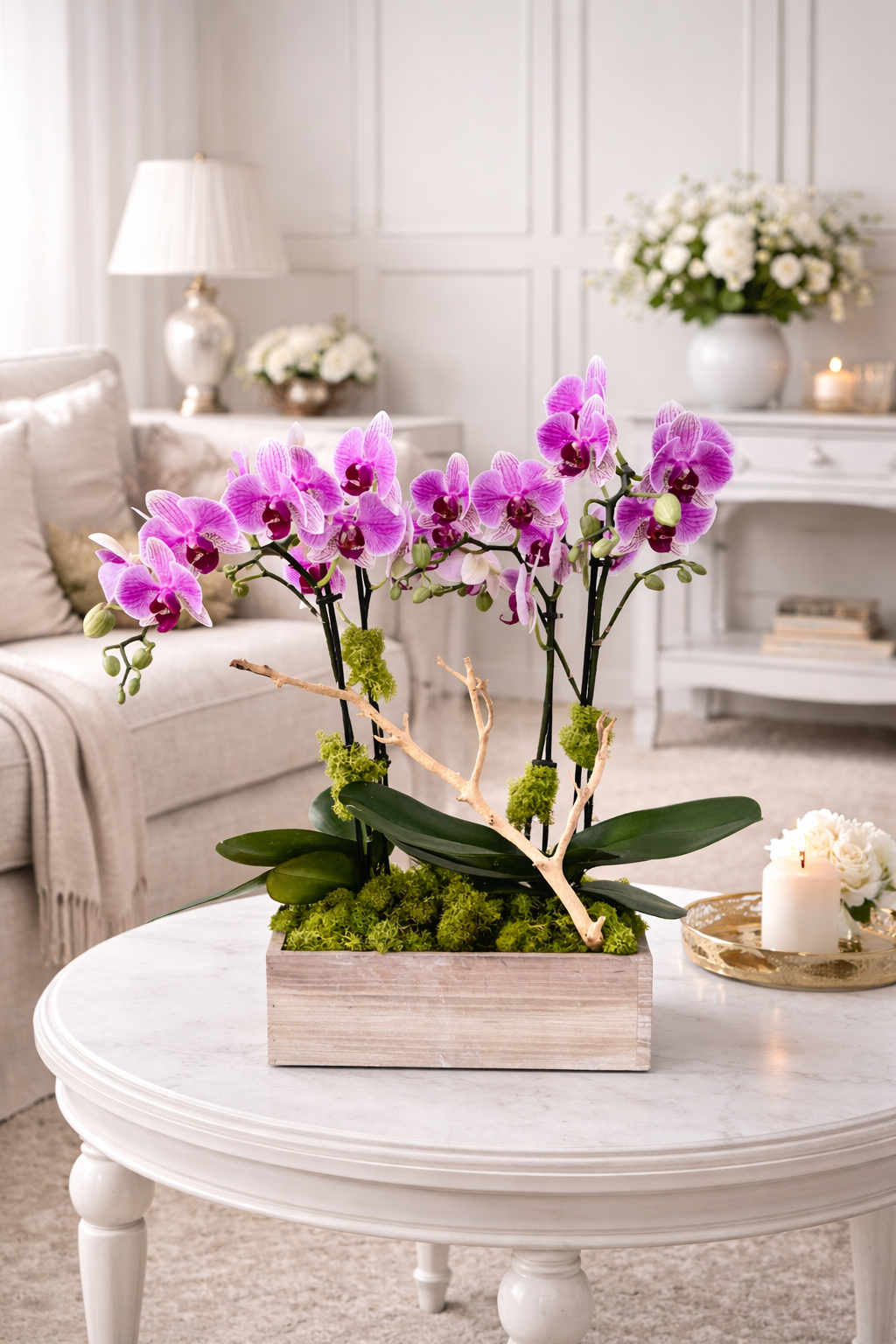 Pink orchids in a wooden box on a white coffee table in a living room.