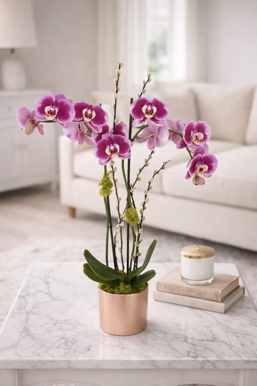 Potted orchid on a marble table with a white sofa and lamp in the background