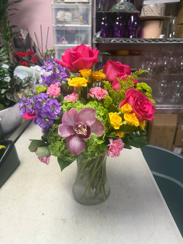 Bouquet of flowers in a clear vase on a table with a blurred background