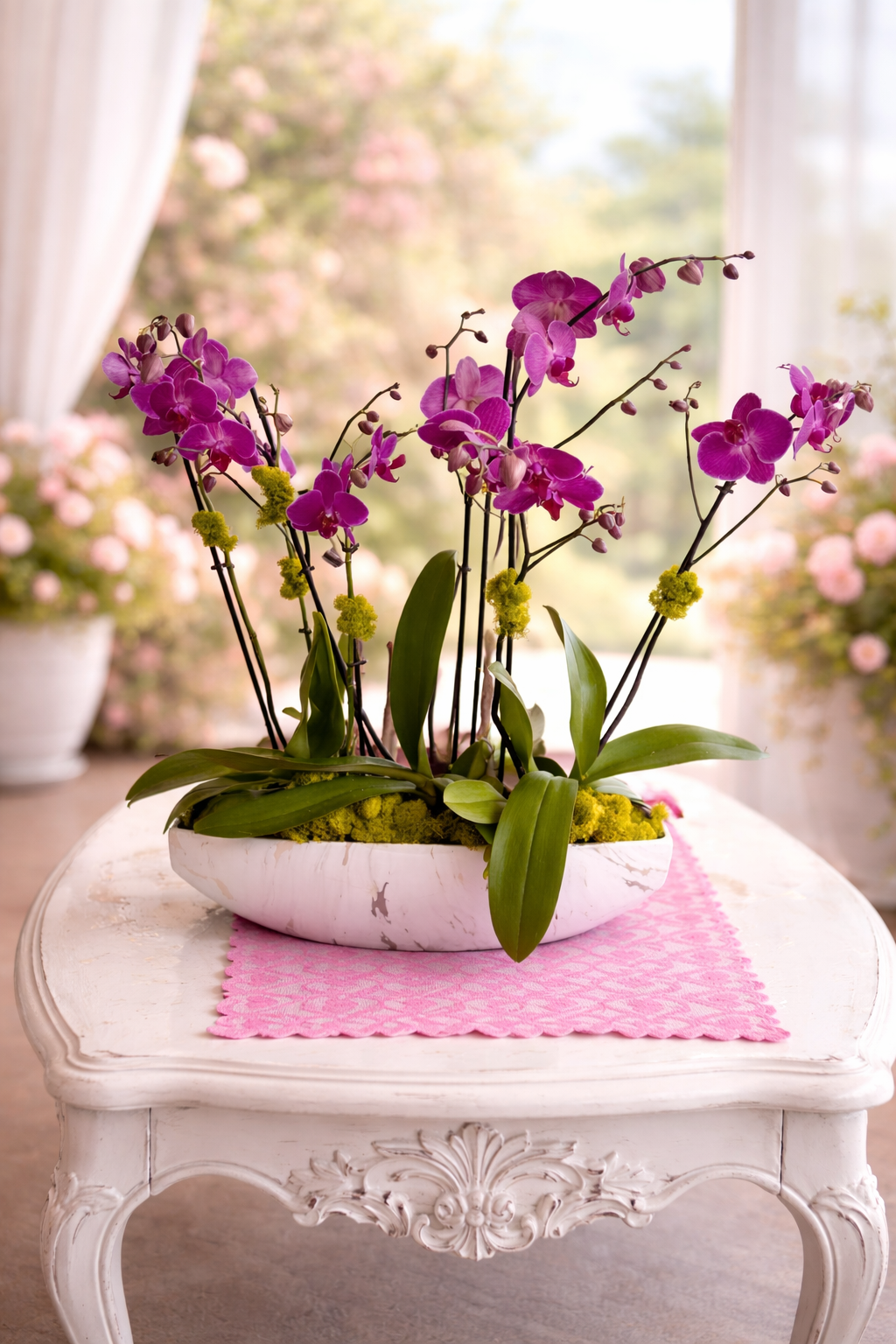 Purple orchids in a white vase on a decorative table with a pink cloth.
